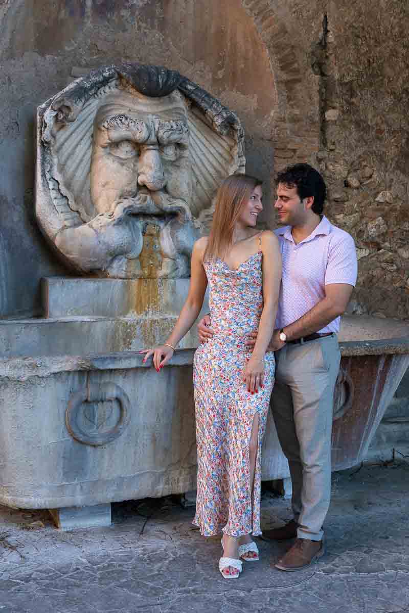 Couple portrait picture taken in color in front of a characteristic roman water fountain