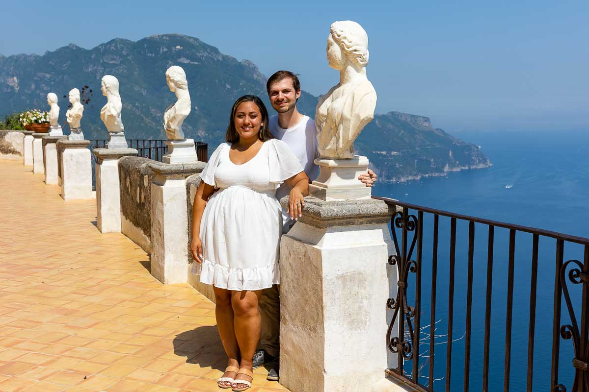Couple posed next to bust statues posing during a photoshoot