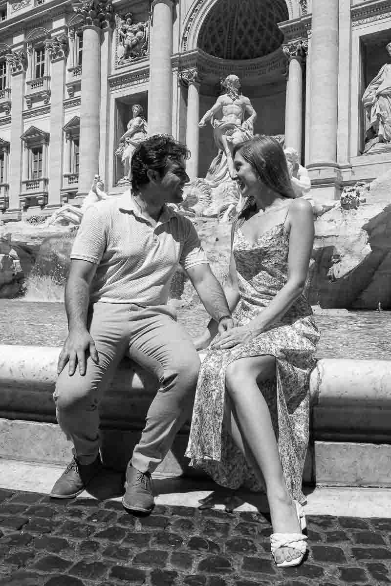 Trevi fountain image of a couple sitting down by the edge of the Trevi fountain