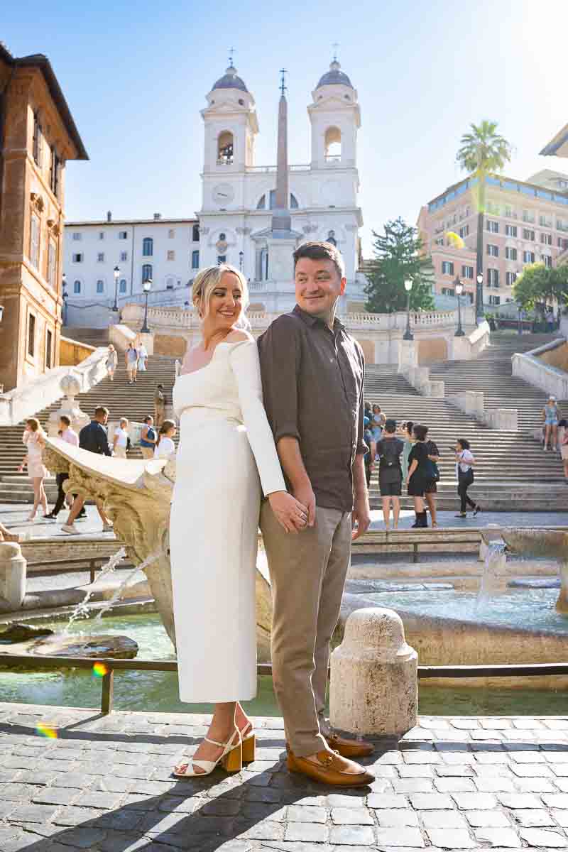 Posing back to back in front barcaccia water fountain in front Spanish steps