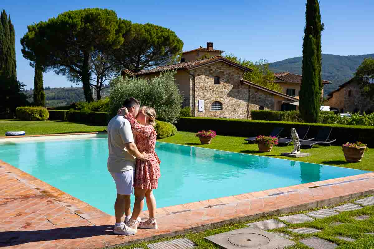 Couple engagement photos taken by the pool with the tuscan winery country house background 