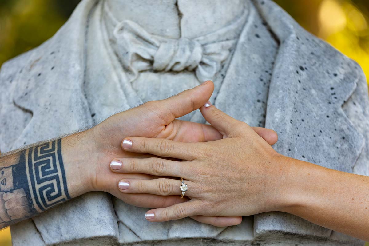 Close up image engagement ring photographed over a marble statue bust 
