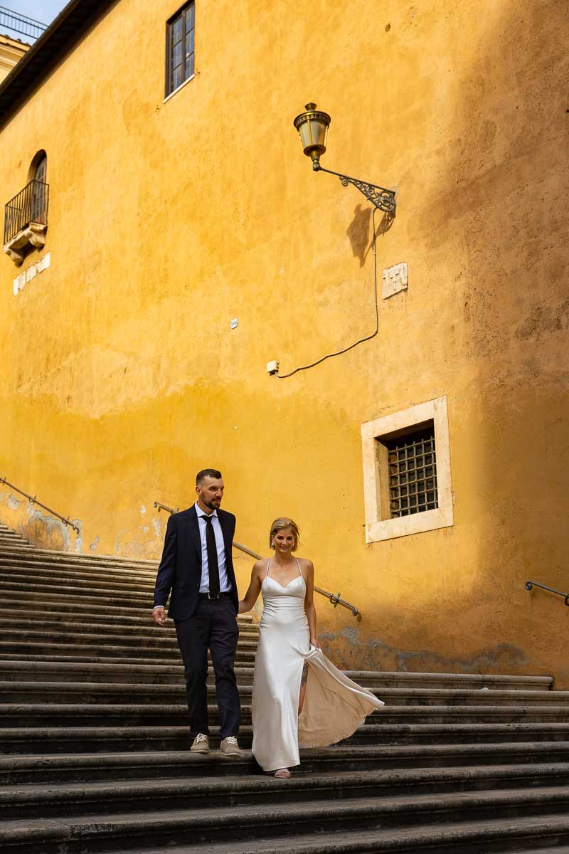 Groom and Bride walking hand in hand down the steps of Piazza del Campidoglio