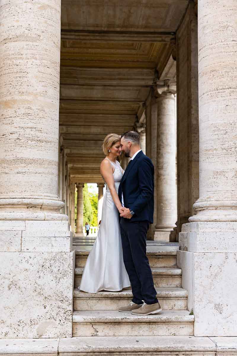 Portrait picture of a couple together under large marble columns 