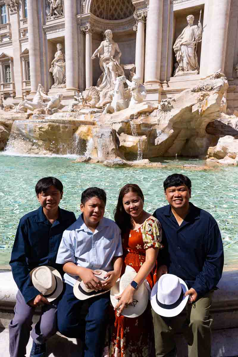 Sitting down on the edge of the Trevi fountain taking pictures during a photoshoot