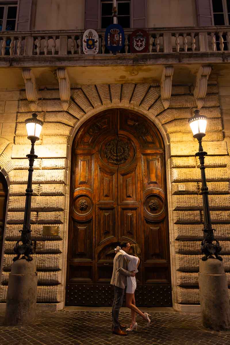 Photography portrait couple photoshoot by a wooden doorway lit at night by two light poles