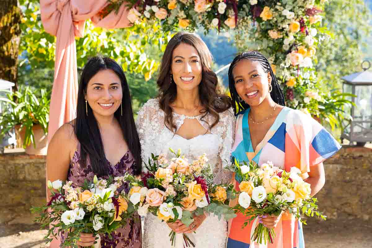 Bridesmaids portrait with the bride photographed in front arch of flowers