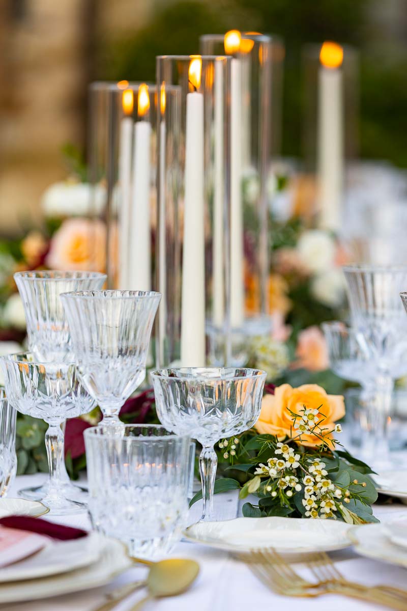 Close up of the decorated table with glasses and lit candles
