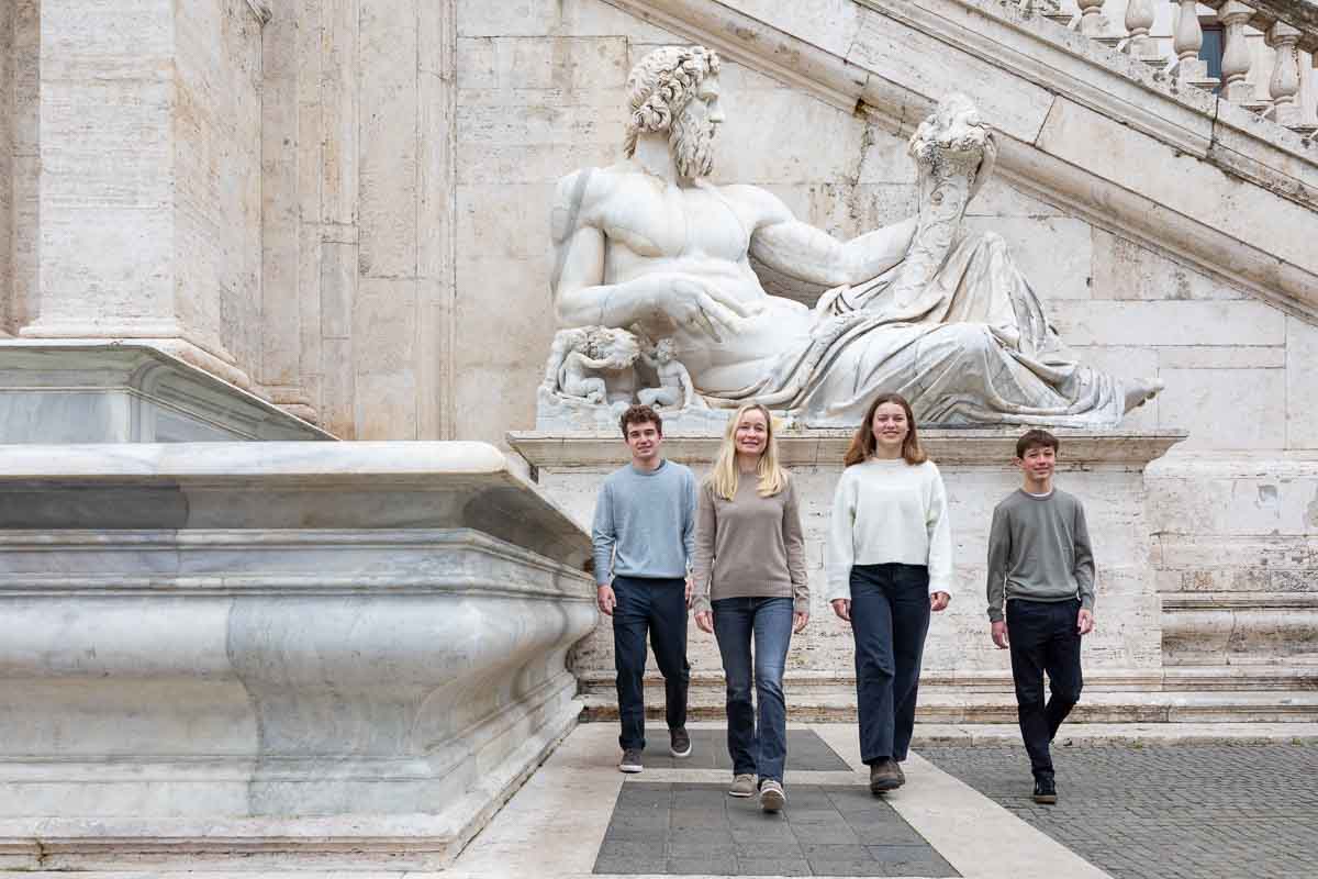 Walking in front of a large white marble roman statue used as background