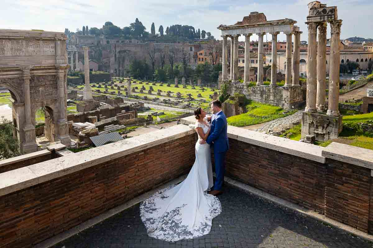 Wedding couple posing by the forum with the view whole ancient city background