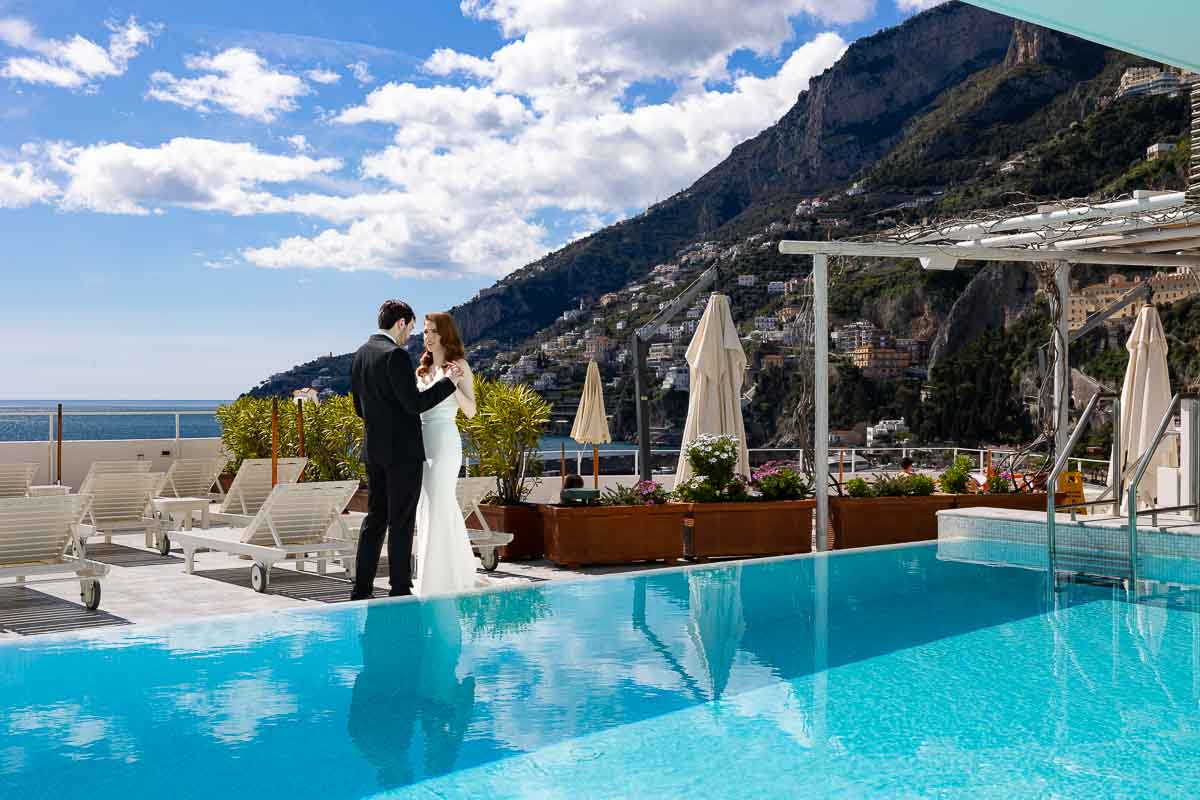 Taking elopement pictures of the newlywed couple with a hotel in the background together with the whole view