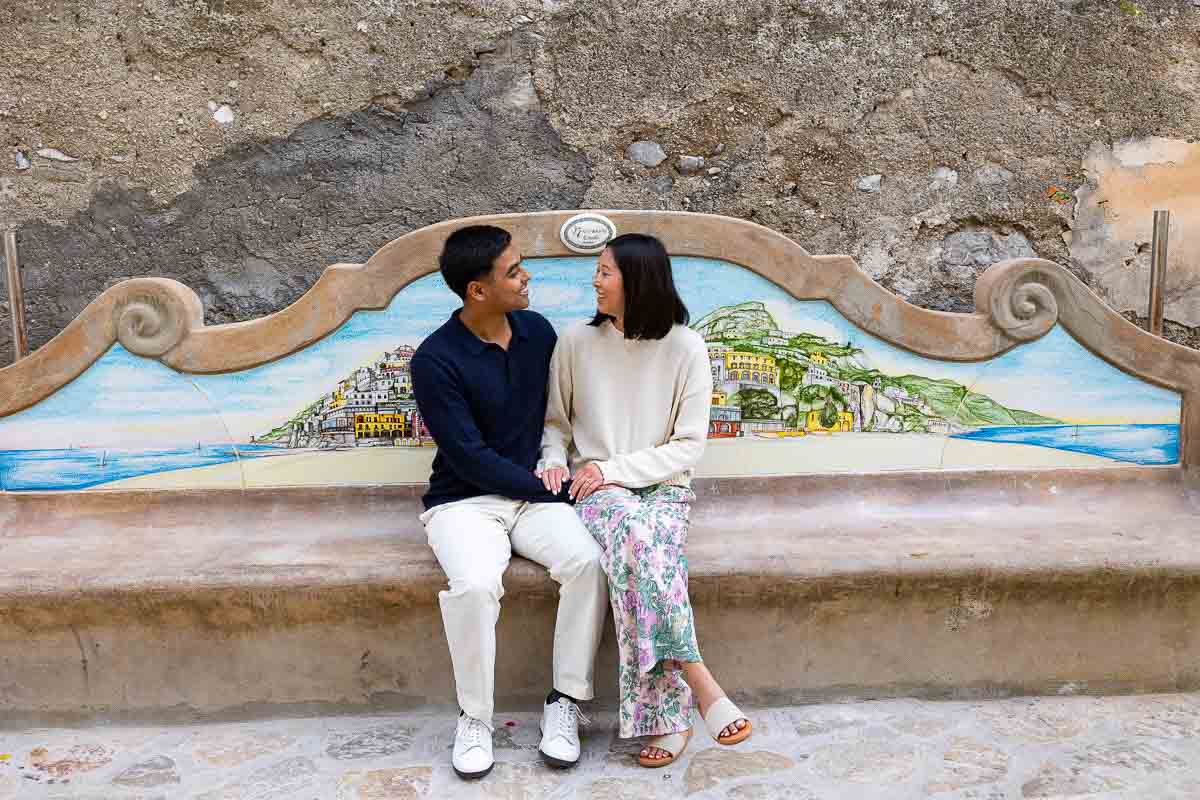 Sitting down on a ceramic bench while taking engagement couple photos 