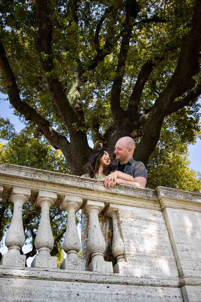 Shooting engagement pictures at the Villa Borghese park in Rome with green trees in the backdrop