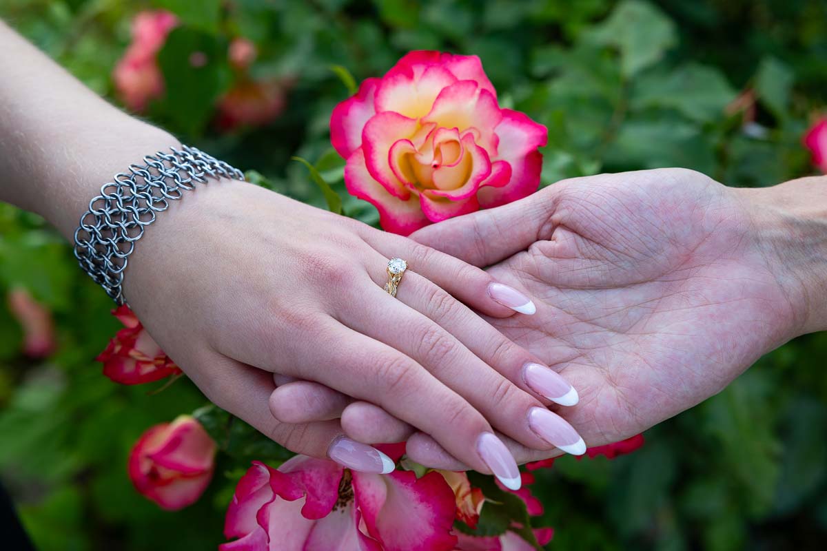 Engagement ring close up while holding hands. Marriage Proposal in Rome