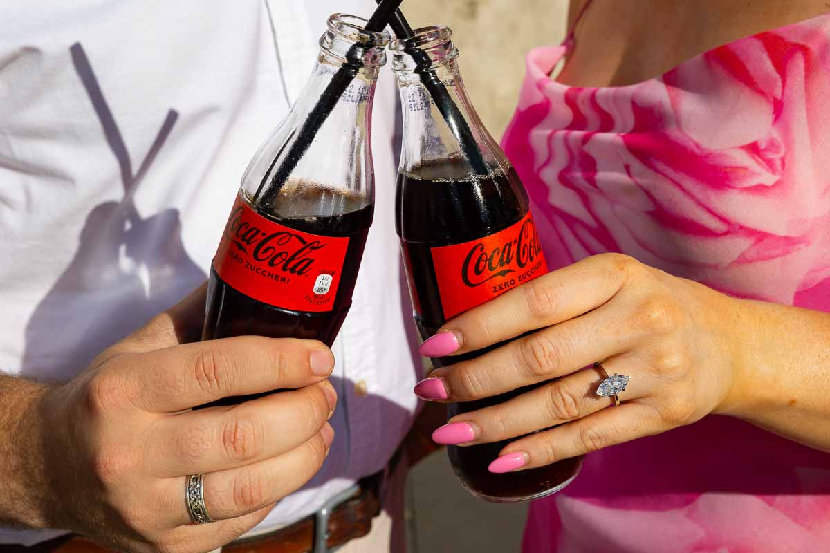 Toasting with coca cola bottles while showing the engagement ring 