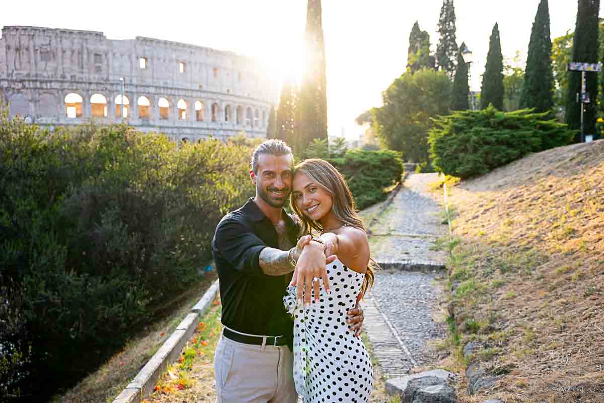 Couple together showing the engagement off the viewer with the Coliseum as backdrop