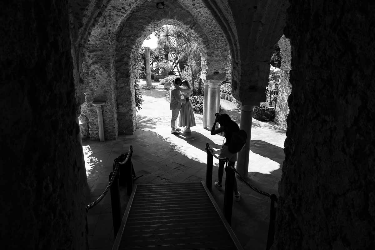 Photographer taking picture of a couple during a Ravello proposing photography session in black and white 