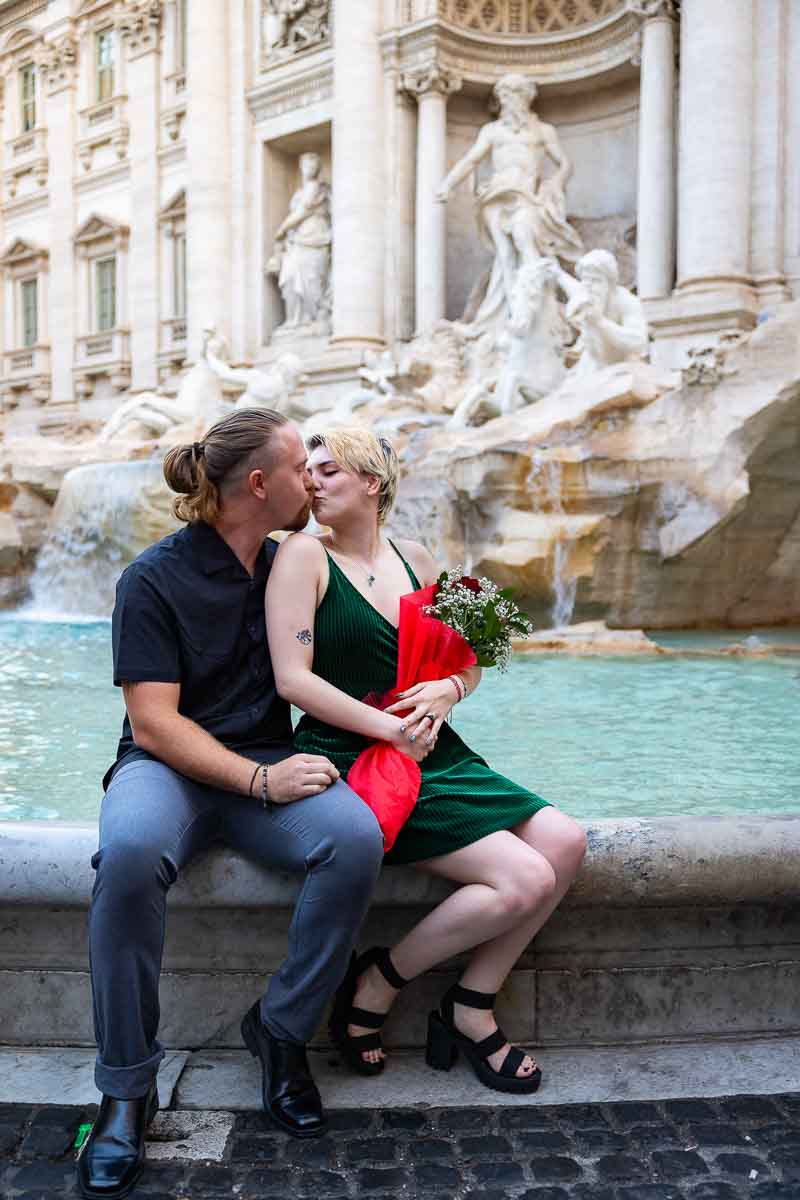 Couple kissing edge of water at Trevi fontana after a romantic surprise wedding engagement