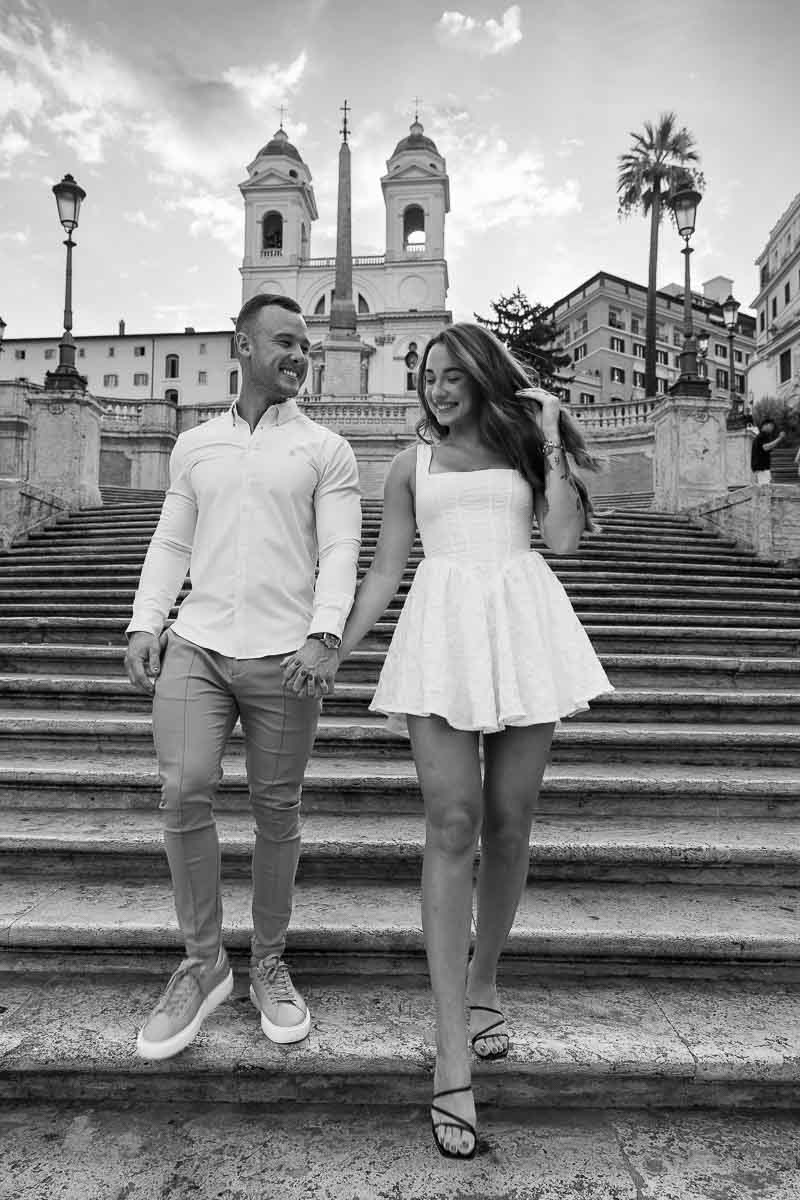 Walking down the Piazza di Spagna staircase holding hands and smiling