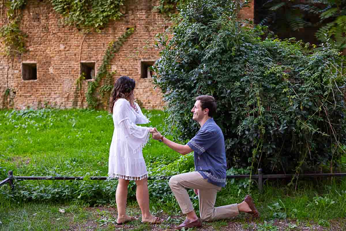 Kneeling down and proposing marriage in the park of Giardino degli Aranci Rome Italy. Orange Garden Sunset Proposal