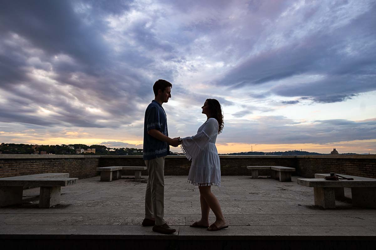 Couple holding hands beautiful sun setting sun while taking couple portraits