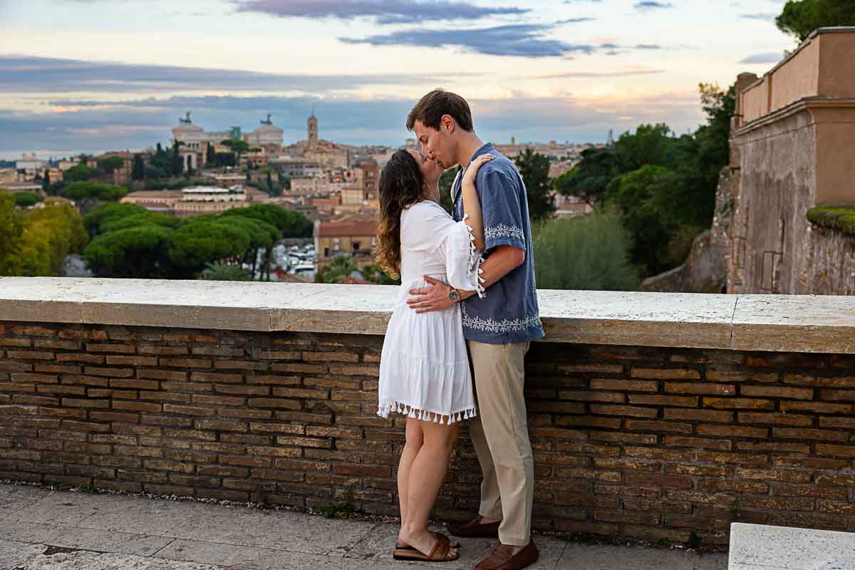 Kissing before the roman skyline after a romantic surprise wedding engagement