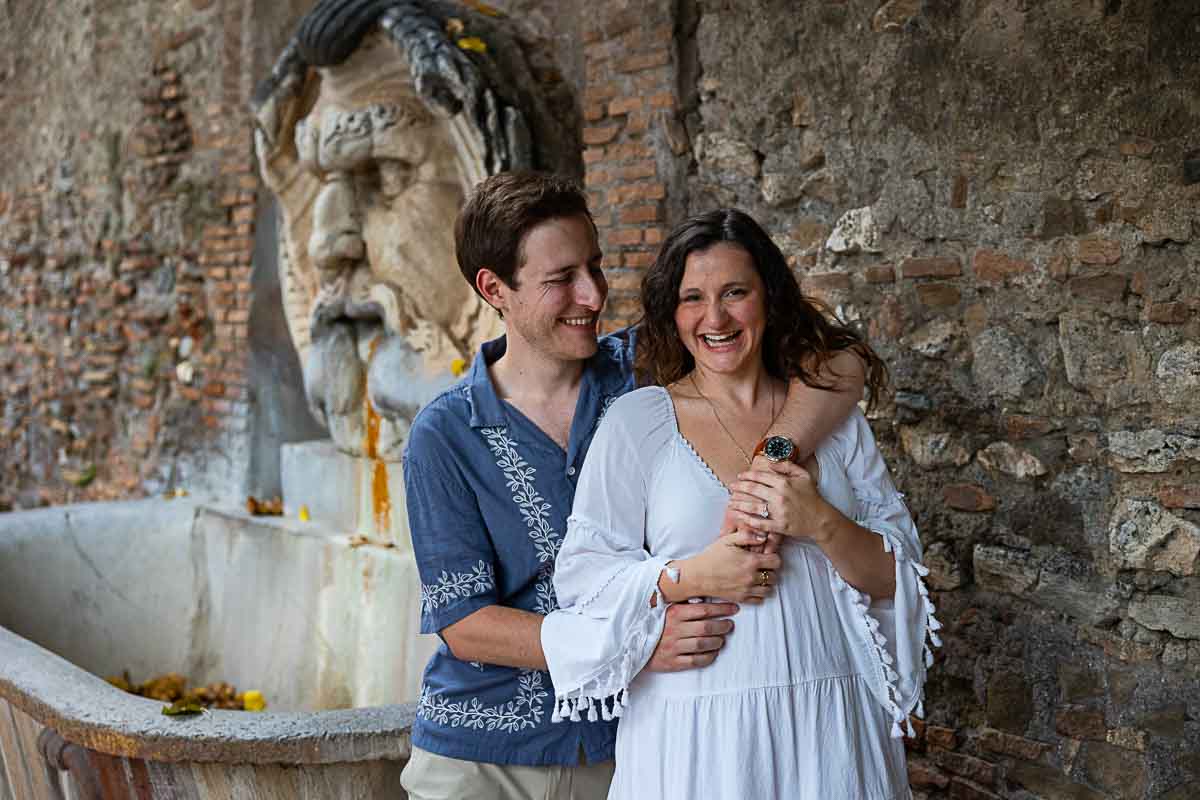 Smiling and happy portrait while shooting in front water fountain found entrance of the park Rome, Italy