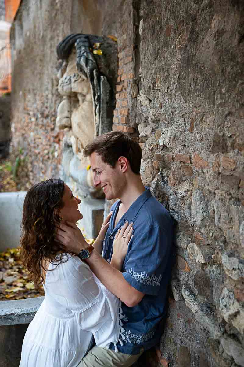 Portrait picture of a couple leaning against the wall by the fountain
