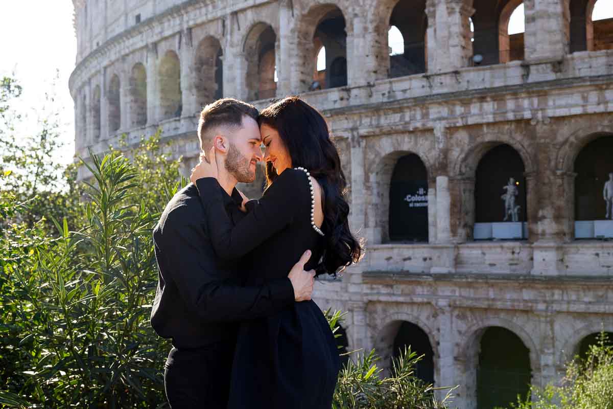 Close up photo of a couple taking pictures Coliseum Italy