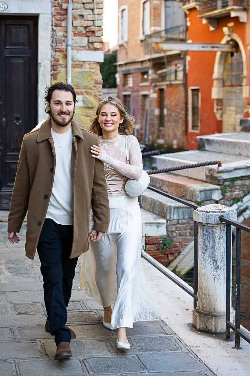 Walking together in love after he proposed on a venetian bridge 