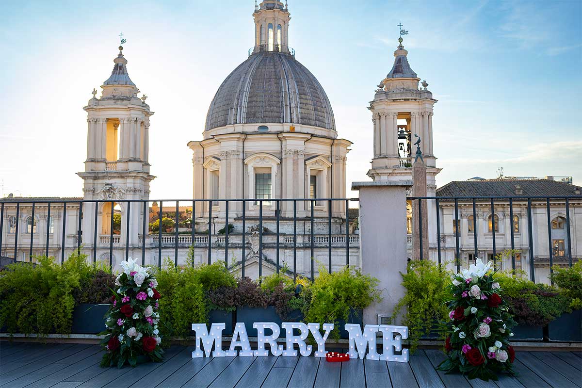 Marry me sign placed on a private terrace with a view of Rome's church dome in the skyline 