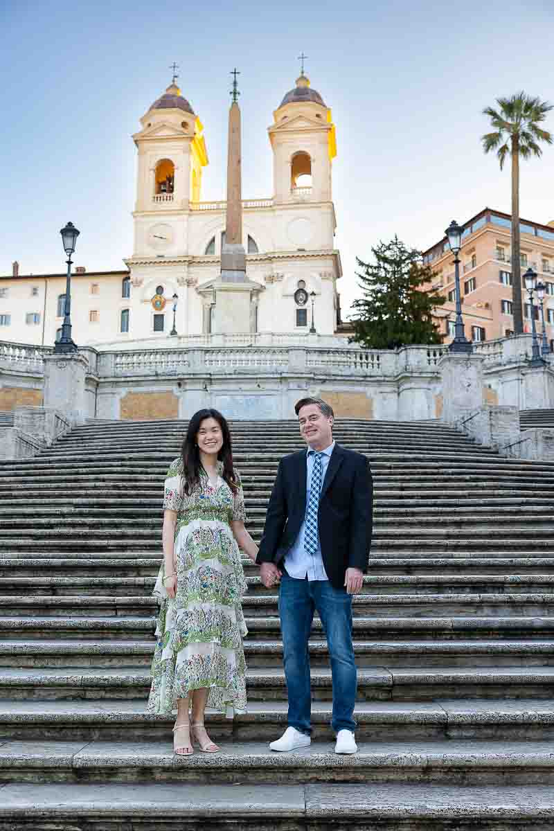 Couple standing on a holding hand pose during a photography session in the early morning dawn light in Italy