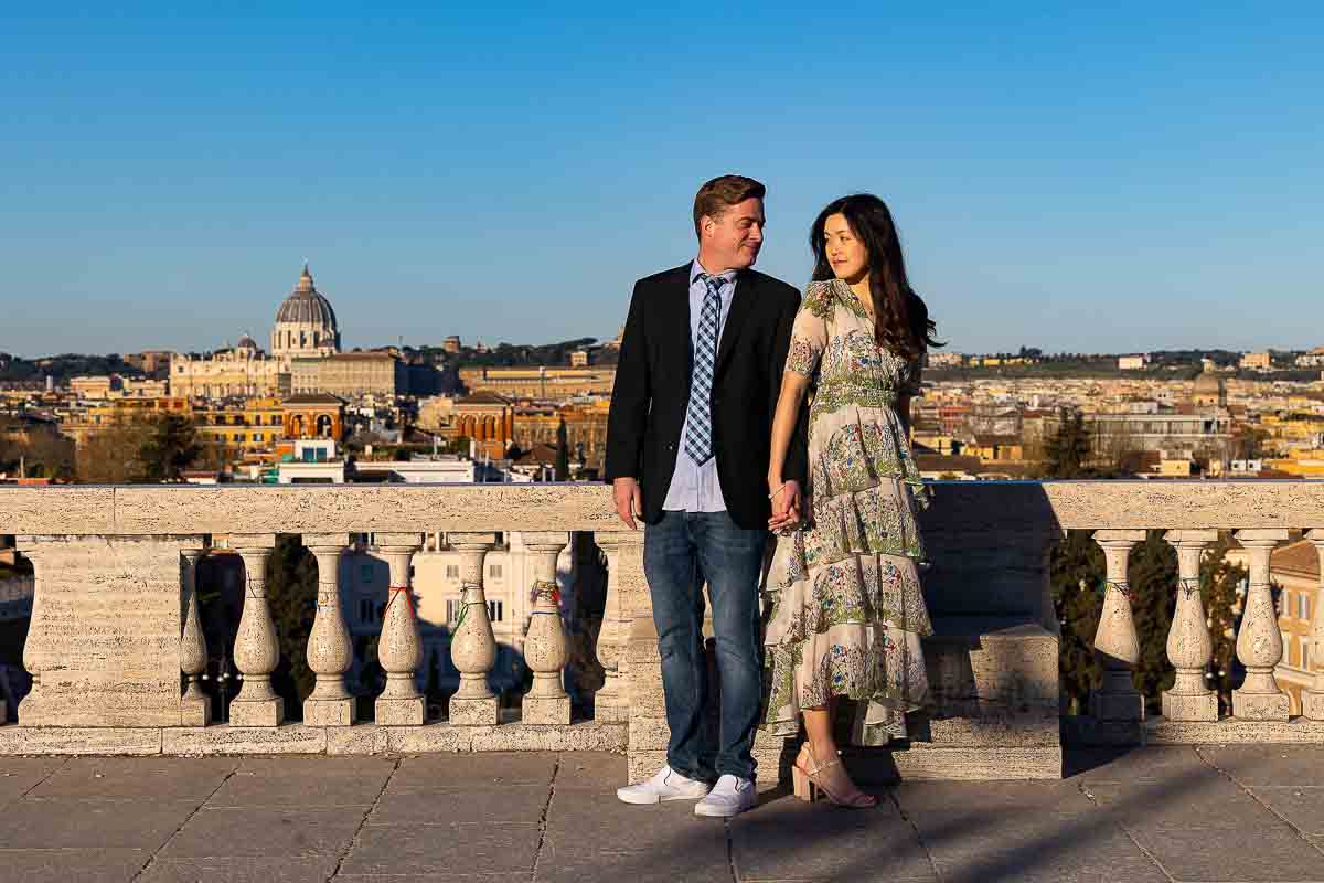 Pincio terrace outlook engagement photos of a couple standing in the early morning light with the cityscape in the far distance