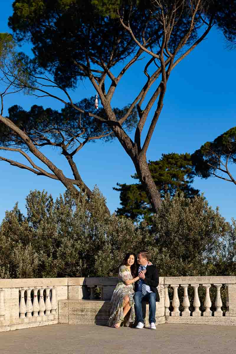 Sitting down underneath Mediterranean pine trees and blue sky in the background