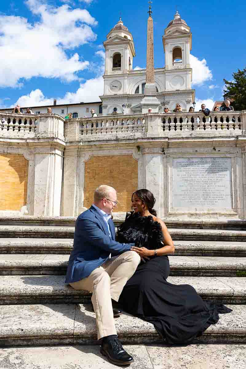 Couple sitting down photographed on the Spanish steps during a pregnancy photography session in Rome Italy