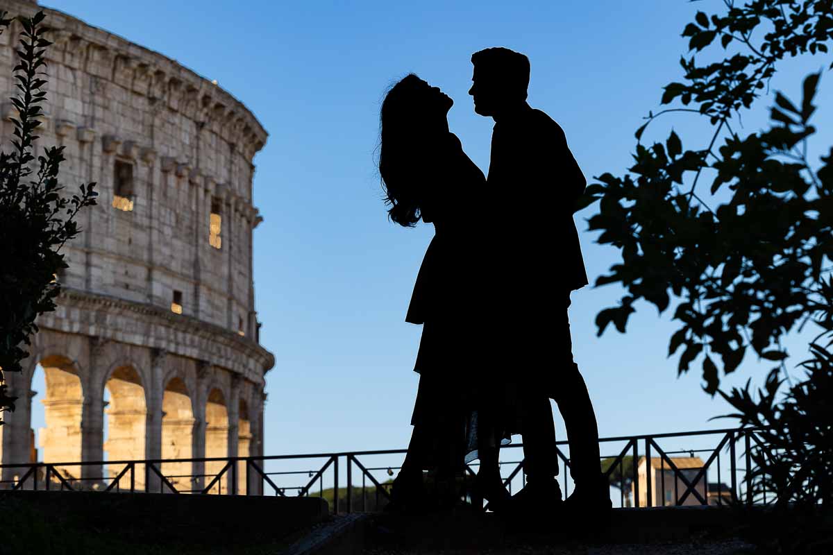 Silhouette photo of a couple photographed against blue sky at the Roman Colosseum during a photographer session. Rome Italy