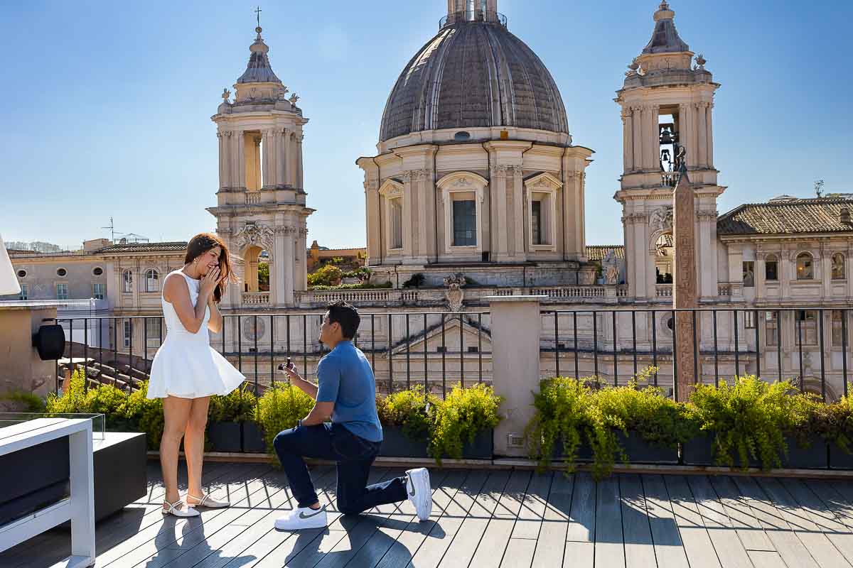 Rome rooftop proposal man kneeling down to ask the big question with the stunning view of the Church in the background 