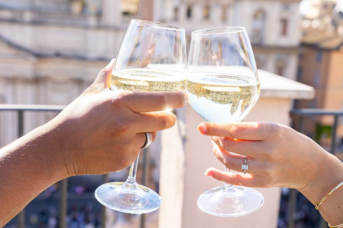 Glass tipping each other celebrating while toasting with prosecco sparkling wine