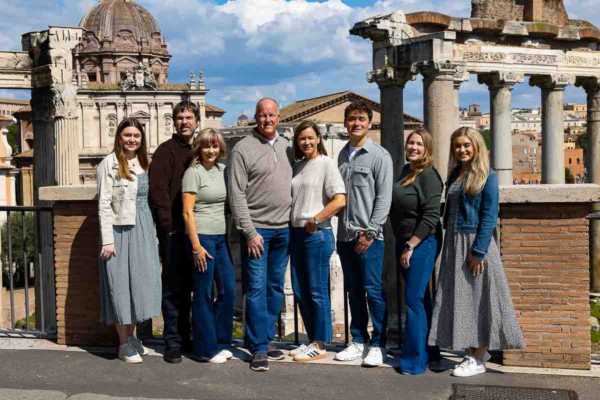 Rome family photography session: A joyful group portrait of a family exploring the ancient Roman Forum, captured by a professional photographic expertise