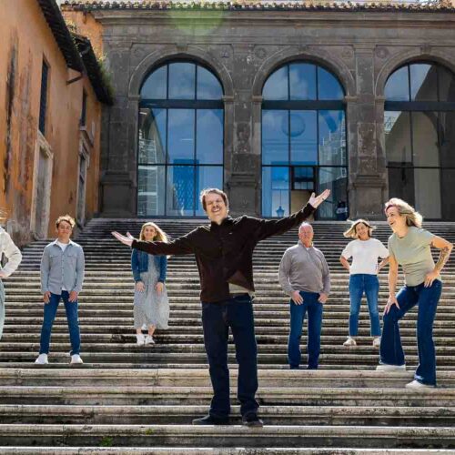 Staircase group photo: A happy family poses on a picturesque staircase during a family photography session in the Eternal City, Rome, Italy.
