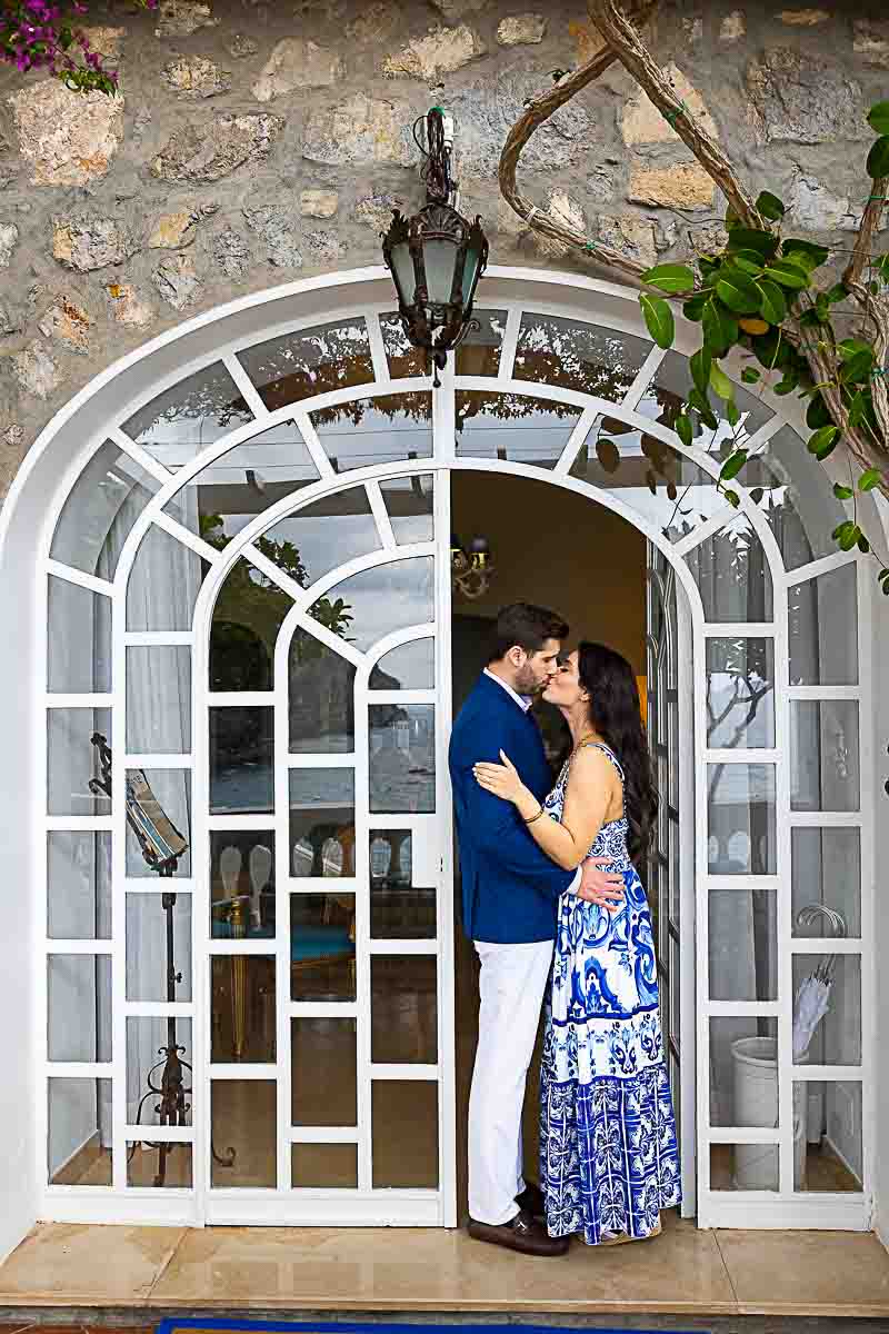 Taking picture of couple together posing underneath a glass doorway as a romantic picture