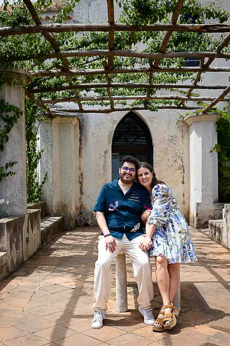 Couple portrait sitting down and looking into the photographic camera after their marriage proposal in Ravello Italy