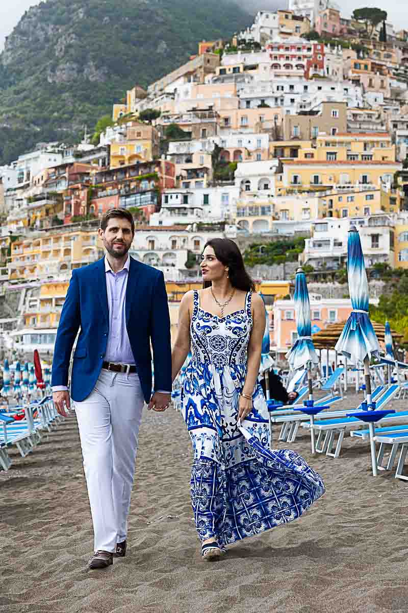 Walking photography session in Positano among typical beach umbrellas and beach beds