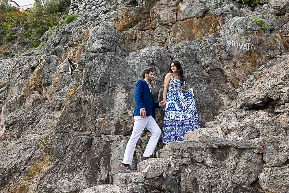 Walking together up the cliff with typical sea rocks all around