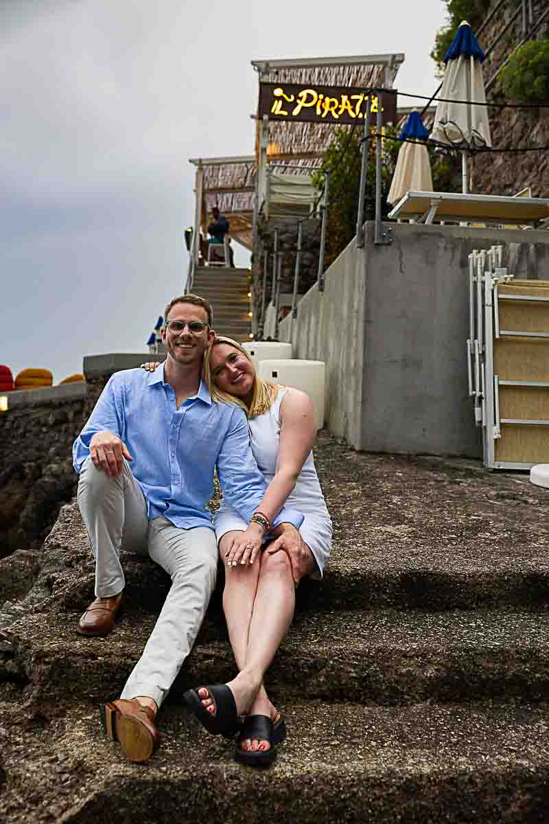Portrait photo of a couple sitting together on the steps at Il Pirata in Praiano