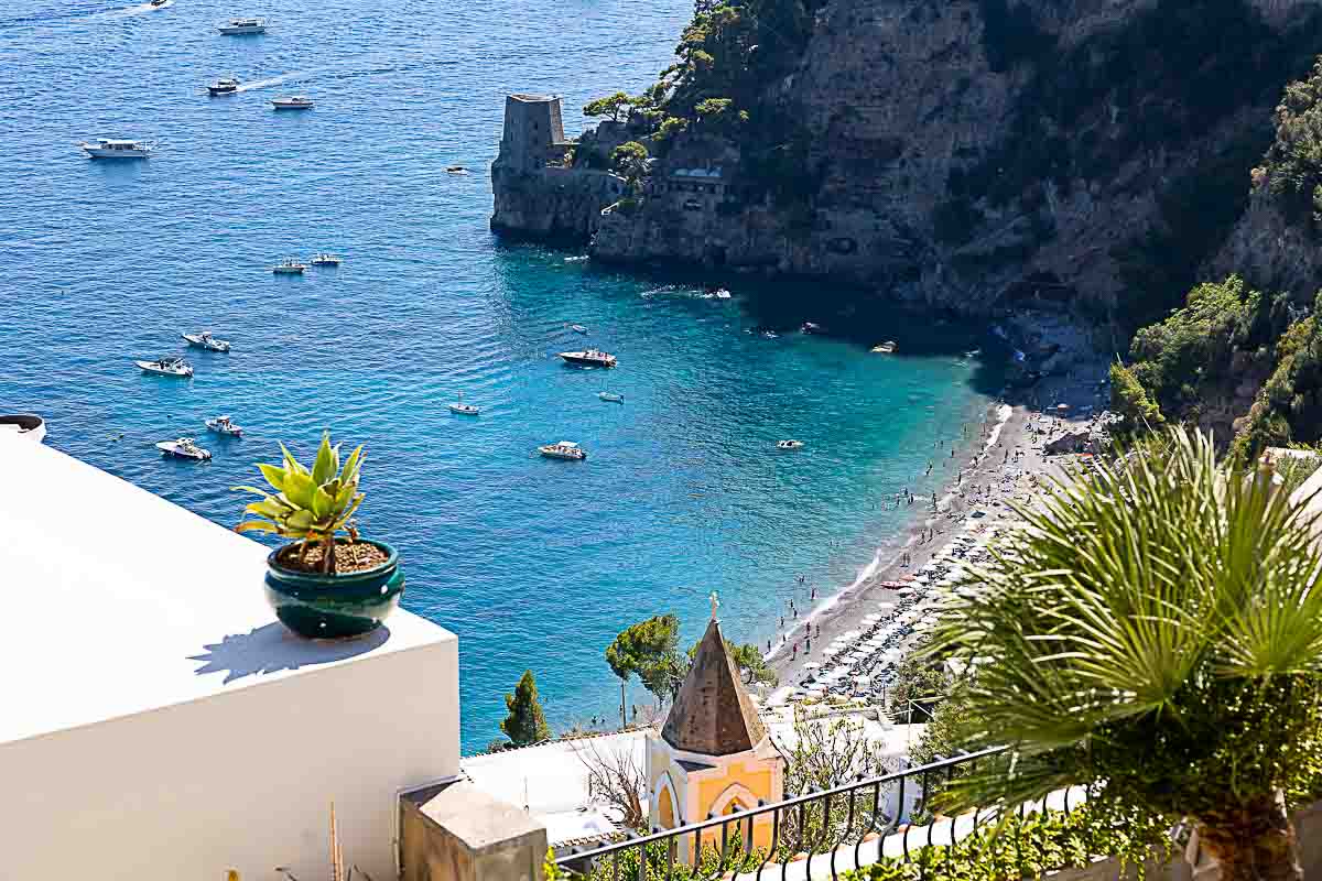 Panoramic aerial view of Fornillo Beach in Positano, showcasing the serene coastline, turquoise waters, and the charming cliffside village