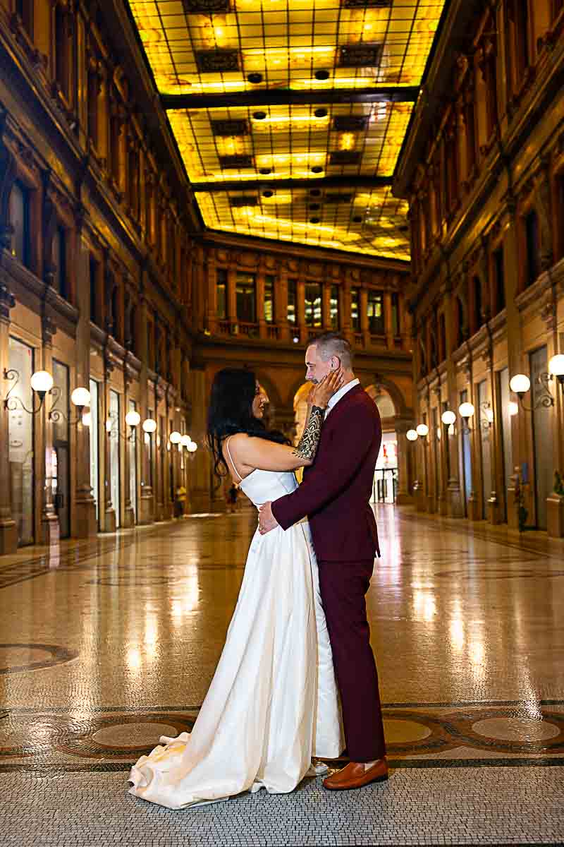 Bride and Groom shot posed underneath a light lit gallery creating a photo scenic look