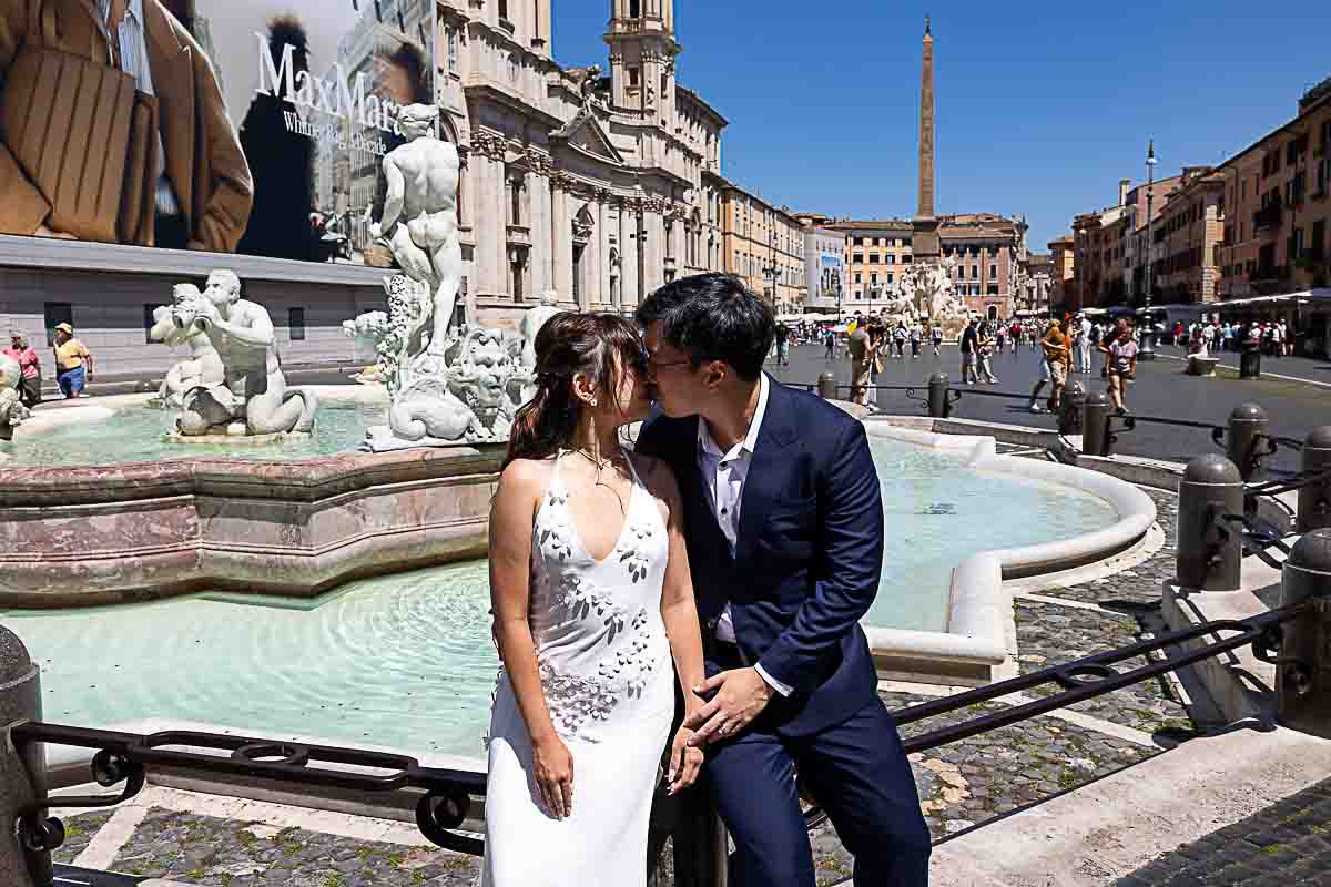 Kissing by the Piazza Navona water fountain Italy during a pre wed photo session