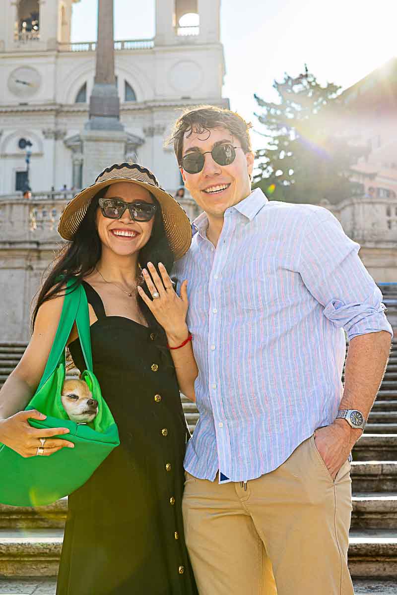 Classic stand up couple portrait on on the staircase with the church in the far background showing off the engagement ring. Spanish steps proposal