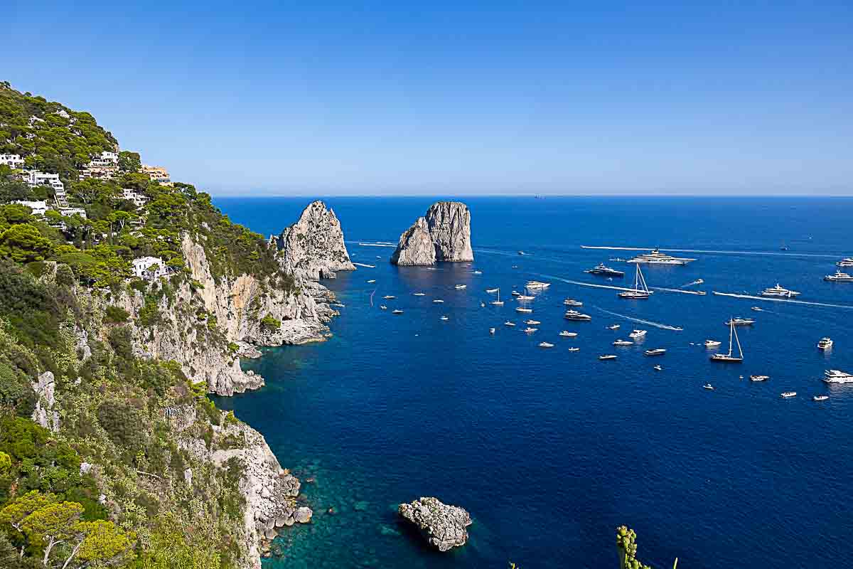 Seaside view from a distance of the Faraglioni rocks on the horizon. Beautiful seascape